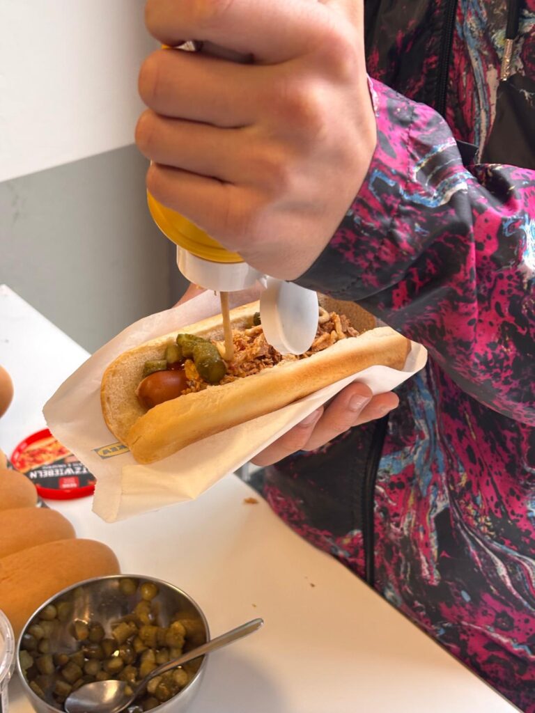 Kind macht Senf auf hot-dog